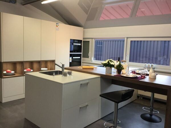 Moderne Einbauküche mit Kochinsel, großen Fenstern und stilvoller Dekoration.